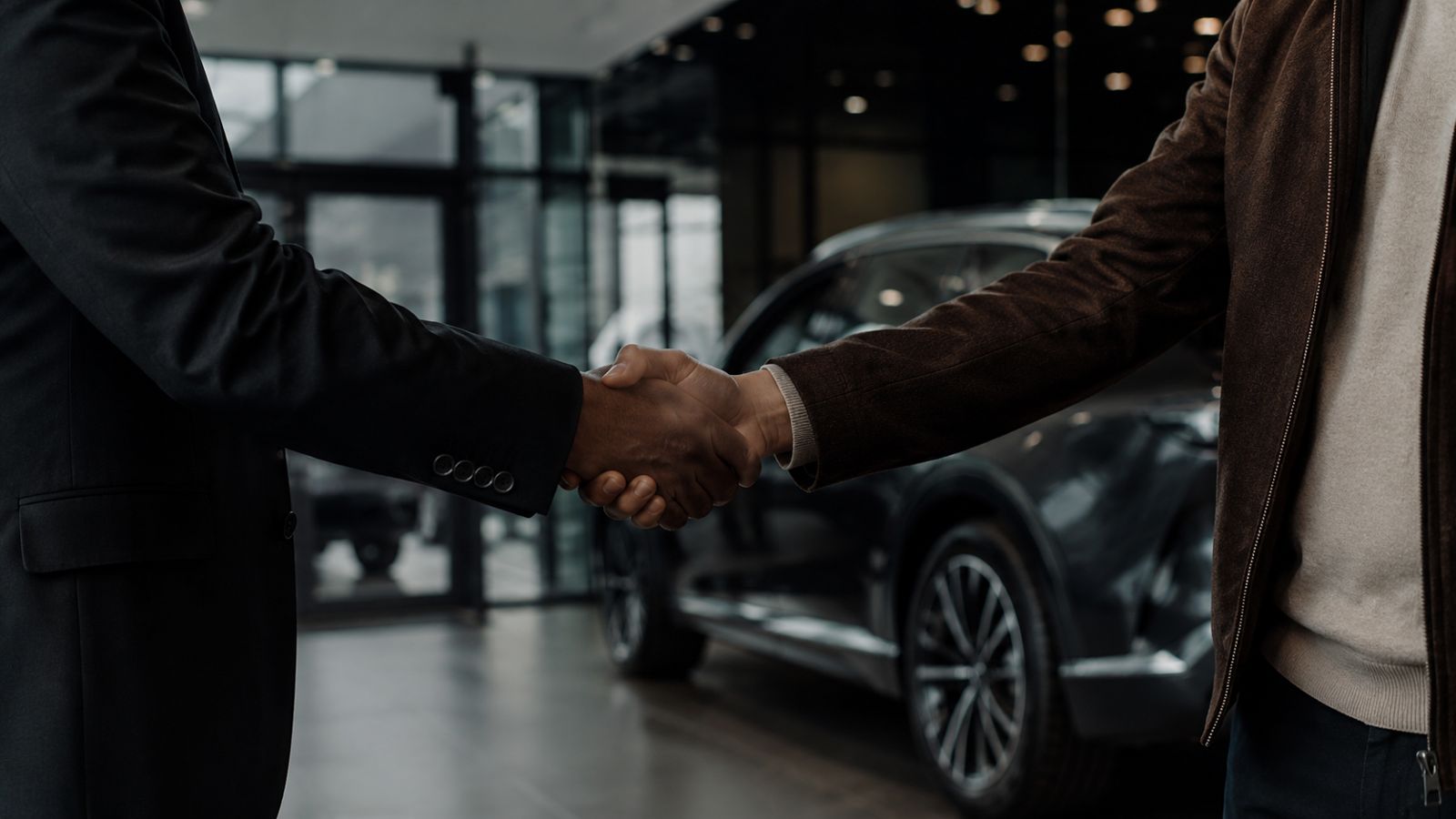 Poignée de main entre un client et un vendeur chez un concessionnaire